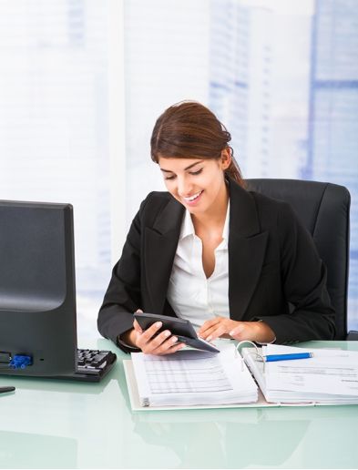 Job bei K-Plus Personalmanagement: Buchhalterin tippt an einem Taschenrechner