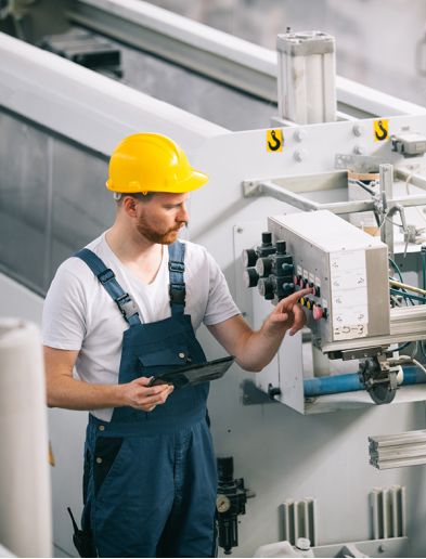 Job bei K-Plus Personalmanagement: Maschinenführer mit Tablet drückt Knopf an Anlage